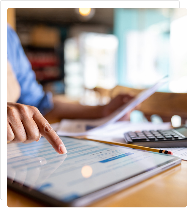 Person interacting with a digital tablet in a workspace.