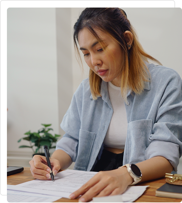 Woman writing in a notebook at a desk.